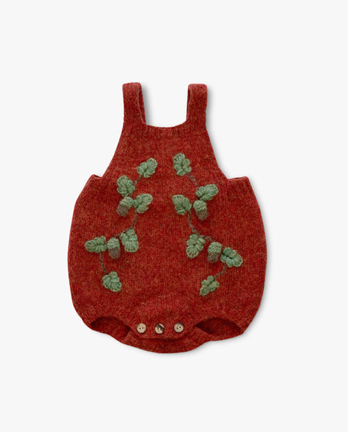 Red baby romper with green leaf patterns on a white background