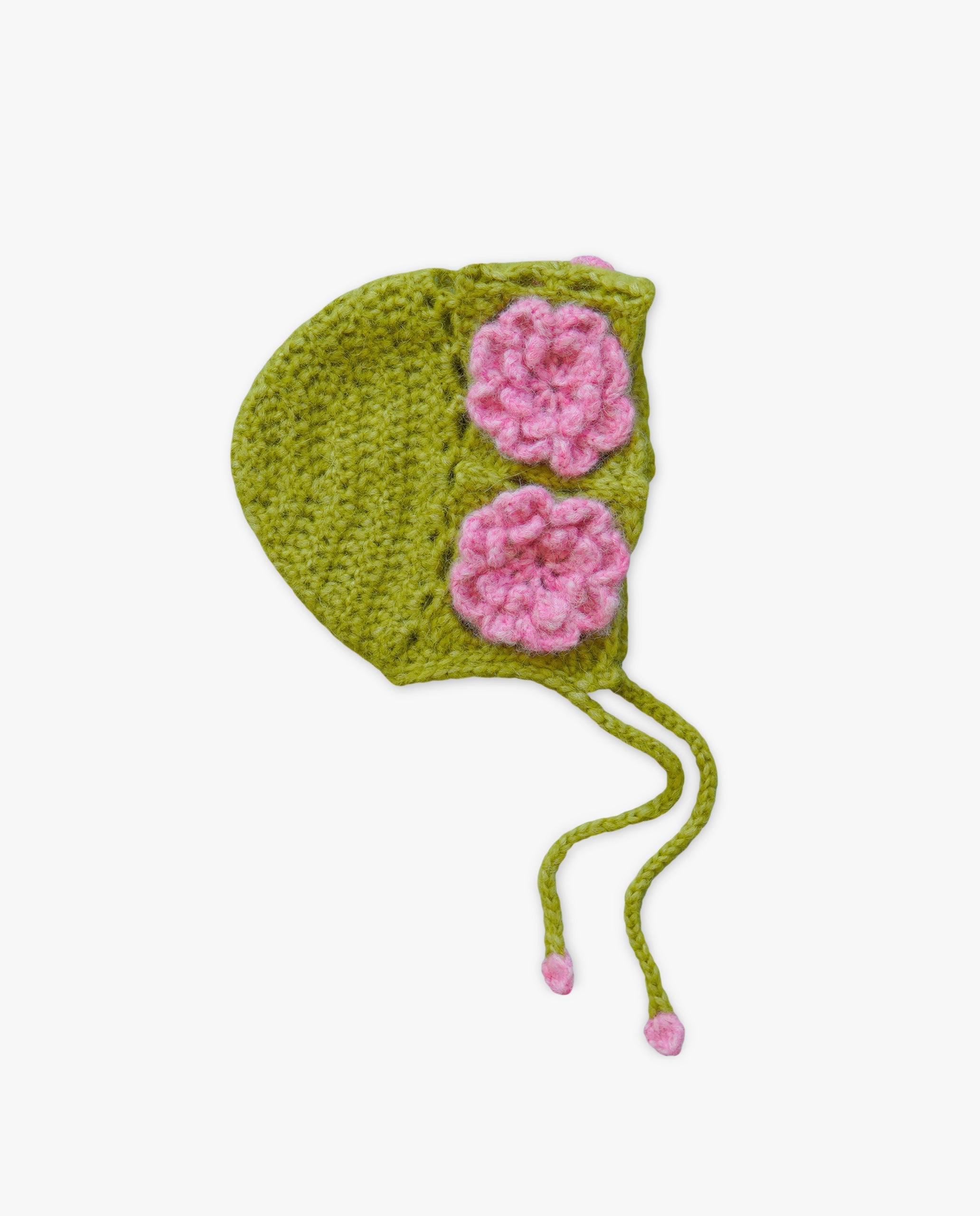Green crocheted baby bonnet with pink flowers on a white background